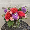 A lush, handcrafted design of stunning deep expression roses, lavender stock, 