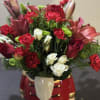 This lush holiday arrangement combines deep red roses, white spray roses, red