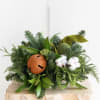 A lush winter centerpiece designed with fresh evergreens, seasonal greenery, and elegant