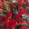 A lush, dramatic seasonal arrangement designed in rich crimson tones. Created with