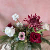 The festive planter is artfully arranged with the season's best flowers and