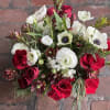 Low and lush white +red winter arrangement of seasonal red accents and