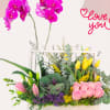 Mixed floral arrangement with pink roses, purple orchids, tulips and fresh green