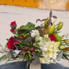 A beautiful centerpiece made of fresh hyadrangea, red roses, white lylis and