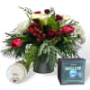 A beautiful arrangement of holiday foliage and winter flowers. Accompanied with a