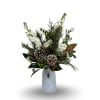 This winter-inspired arrangement features soft white blooms, seasonal greenery, frosted pinecones, and