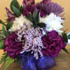 THIS IS A CUBE ARRANGEMENT WITH ALL PURPLE AND WHITE FLOWERS TO