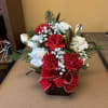 MIXED WHITE AND RED CARNATION WITH CHRISTMAS GREENS INSIDE A CUBE WITH