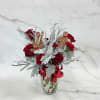 A winter-forward floral design combining classic red roses, soft dusty miller, and