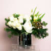 White roses, peonies and assorted white florals among holiday greens and ornaments