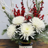 Frosty the Snowman vase filled with Christmas greenery and seasonal flowers. 