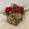 Centerpiece of fresh flowers and pine cones in a stylish wooden box.