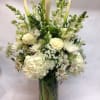 This arrangement contains a seasonal blend of white flowers including elegant calla