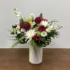 A timeless winter arrangement featuring crisp white mums and lisianthus, rich burgundy