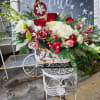 A beautiful rustic snowman sleigh designed with lots of winter evergreens red