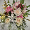 A refined festive floral arrangement featuring soft pink and cream roses, pink