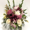 A refined festive floral arrangement featuring soft pink and cream roses, pink