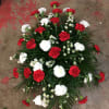 Standing spray with red and white carnations and matching filler. Florals may
