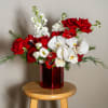 A romantic Christmas arrangement of rich red blooms, soft winter whites, and