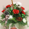 In a wooden box, there is a Christmas arrangement filled with winter