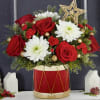 holiday flowers arranged in a christmas drum