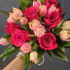 Beautiful hand-tied bouquet of a six red roses and ten pink tulips