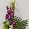 A contemporary floral design featuring cascading purple dendrobium orchids accented with fresh
