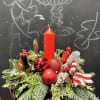 This festive design features a striking red pillar candle nestled into a
