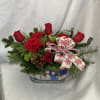 A delicious blend of red roses and carnations with lush Christmas greens