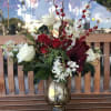 A rich, beautiful arrangement in a festive holiday vase. Contains all of