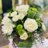 Classy arrangement in a glass square vase filled roses, white spiders, green