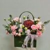 This chic and romantic floral arrangement, elegantly presented in a carrying bag