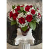 A lavish bouquet of two dozen enchanting red roses, interspersed with delicate