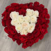 A lush hand tied bouquet of ivory and red roses shaped into