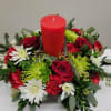 Modern Pillar candle centerpiece made with an assortment of evergreens, red roses