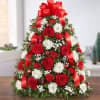Tree-shaped arrangement with red roses and mini carnations; white cushion poms; accented