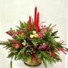 A festive holiday arrangement featuring lush evergreen branches accented with vibrant red