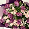 A luxurious bouquet of rich lavender roses paired with soft blush spray