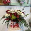 This floral arrangement is atop a decorative pedestal. The bouquet is set