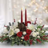 Winter evergreen floral centerpiece with taper candles, holiday trim, white tulips and