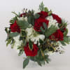 White and red flowers with Christmas greens (greenery may vary). 