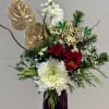 A classic Christmas floral design with reds, greens, and natural textures that