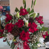 A beautiful Christmas arrangement of roses decorated with acorns and golden cherries.
