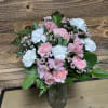 This delicate arrangement includes pink alstroemeria, pink carnations, white miniature carnations, leatherleaf