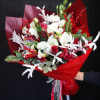 The Crimson Frost Bouquet is a dazzling holiday arrangement that captures the
