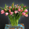 20 stems of tulips beautifully laid out in a 6x6x2in glass vase.