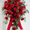 Red carnations and red roses are elegantly arranged and accented with a