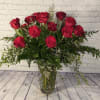 Twenty-four beautiful red roses are hand arranged amongst a variety of lush