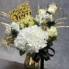 A sophisticated arrangement of creamy white hydrangeas, soft ivory blooms, and dramatic
