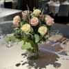 Beautiful Mondial roses arranged with assorted foliage and fillers in a tall